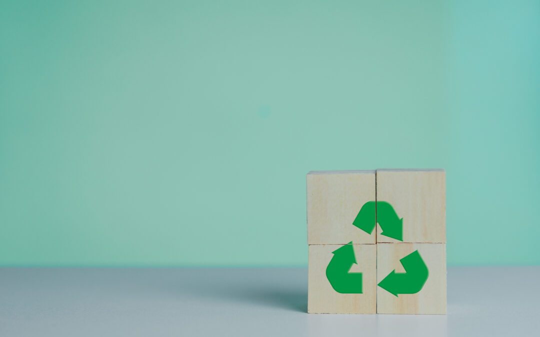 Wooden cubes with a green recycling symbol on them.